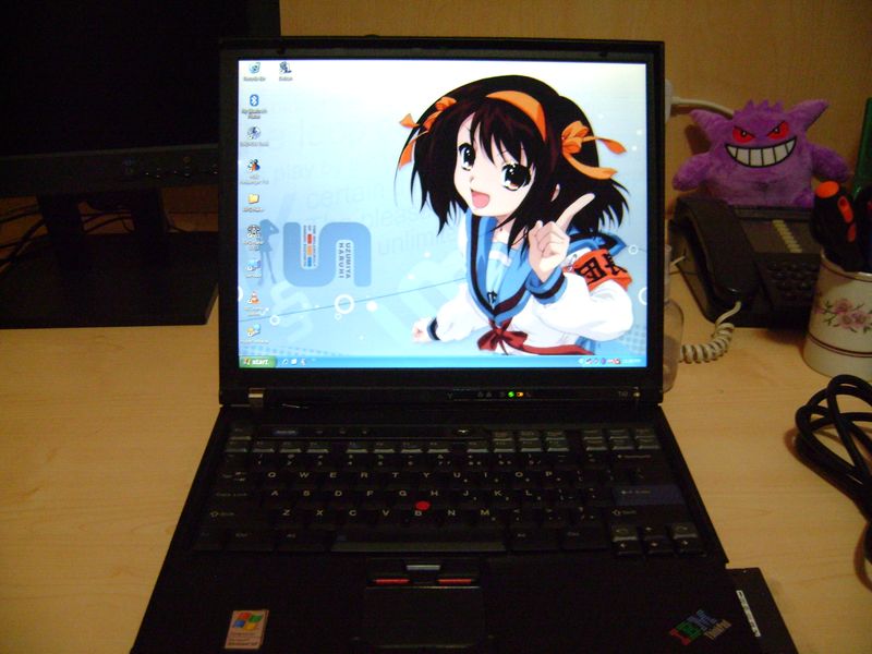 laptop showing windows xp desktop with a haruhi suzumiya background